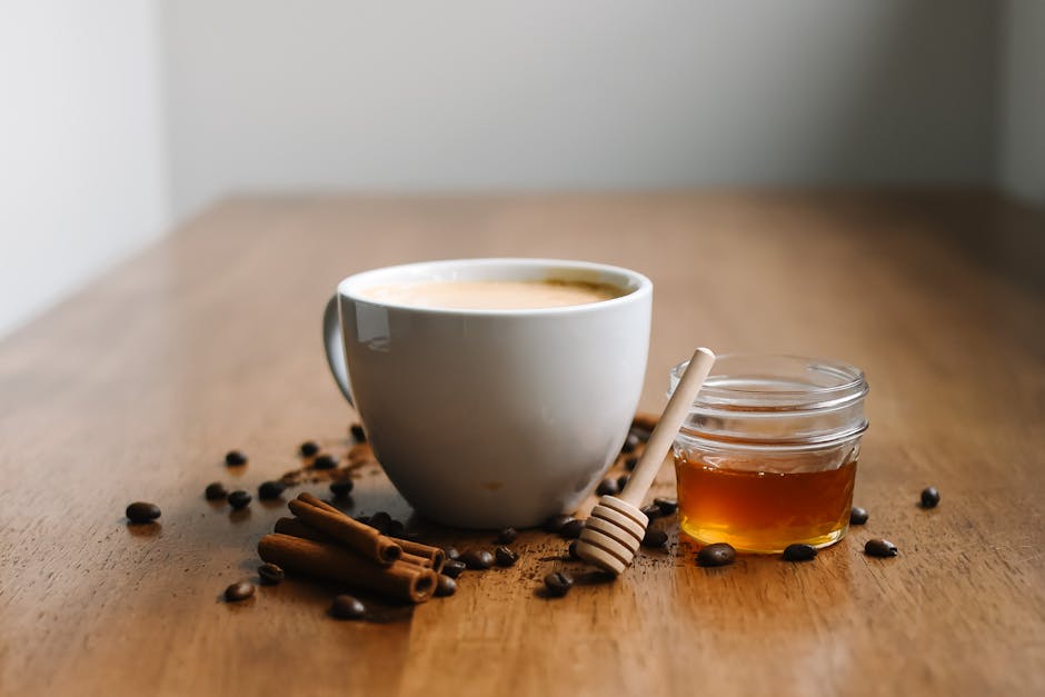Close-up of a warm glass of chai with honey and cinnamon sticks